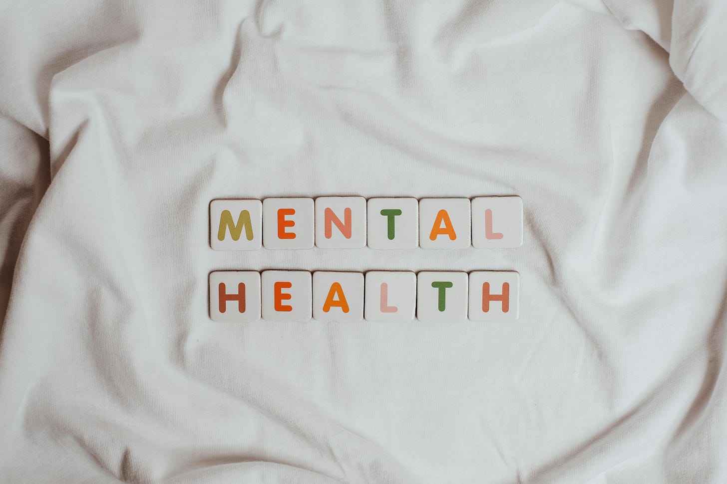 White background with colored tiles spelling Mental Health White background with colored tiles spelling Mental Health
