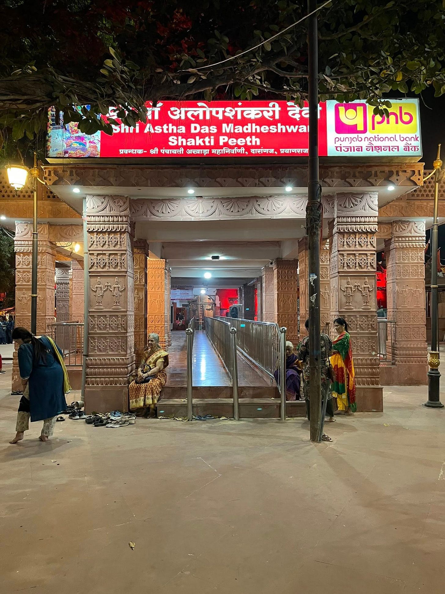 May be an image of temple and text that says 'प्रवन्दक 计 अलोपशंकरी देह Shri Astha Das Madheshwai Shakti Peeth श्री पवायली अखादा महानिर्वाणी, वारानग, प्रबानराज 4pb phb punjabnationalbani punjab national bank पंजाव नेशनल नेक MMMAMHblblЙ MИHИMИwИm NeceeeR 国本通港原番理理'