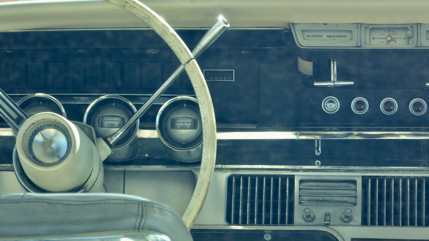 Dashboard of a vintage vehicle, with wheel gear and old fashioned radio.