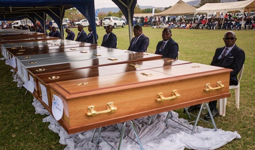 Funeral pallbearers sit behind caskets during a memorial service for the victims of a ferry that capsized on Lake Kariba in Kariba, Zimbabwe, Thursday, Aug. 13, 2026. (AP Photo/Mkhululi Thobela) Funeral pallbearers sit behind caskets during a memorial service for the victims of a ferry that capsized on Lake Kariba in Kariba, Zimbabwe, Thursday, Aug. 13, 2026. (AP Photo/Mkhululi Thobela)