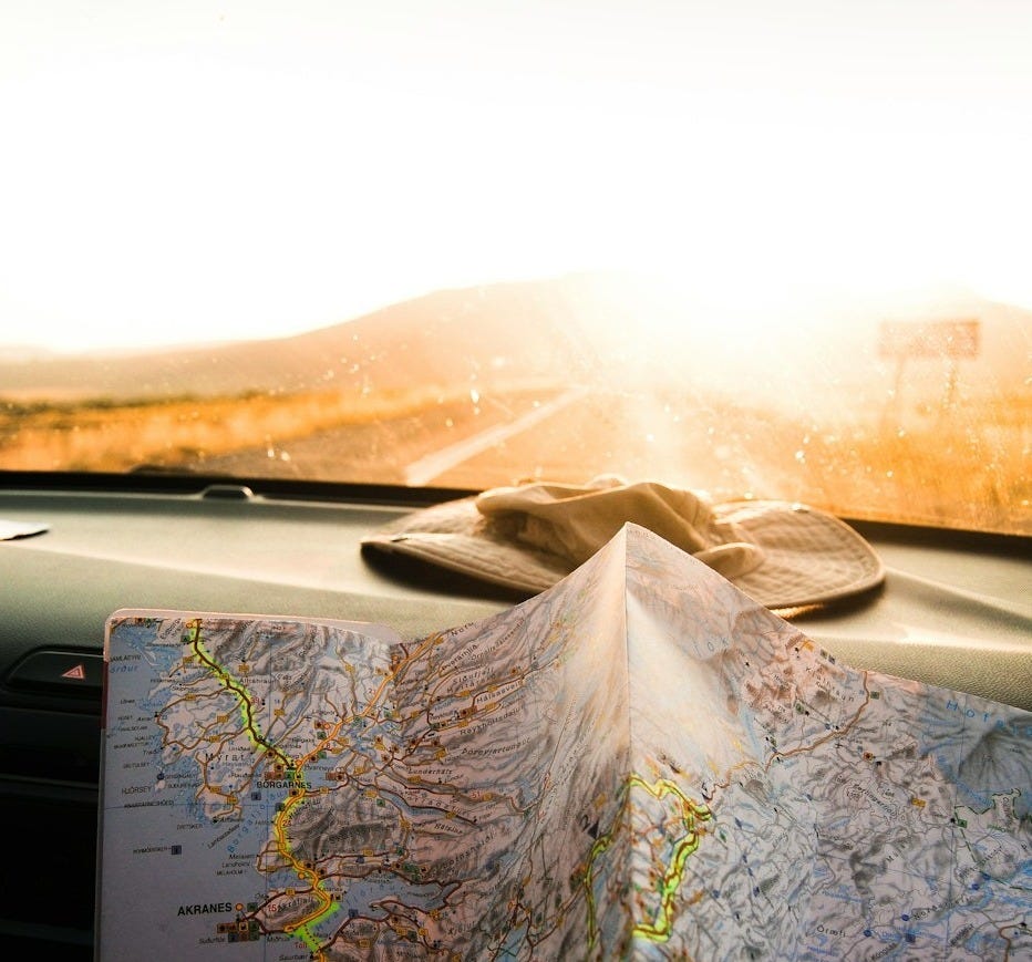 person holding blue and brown map