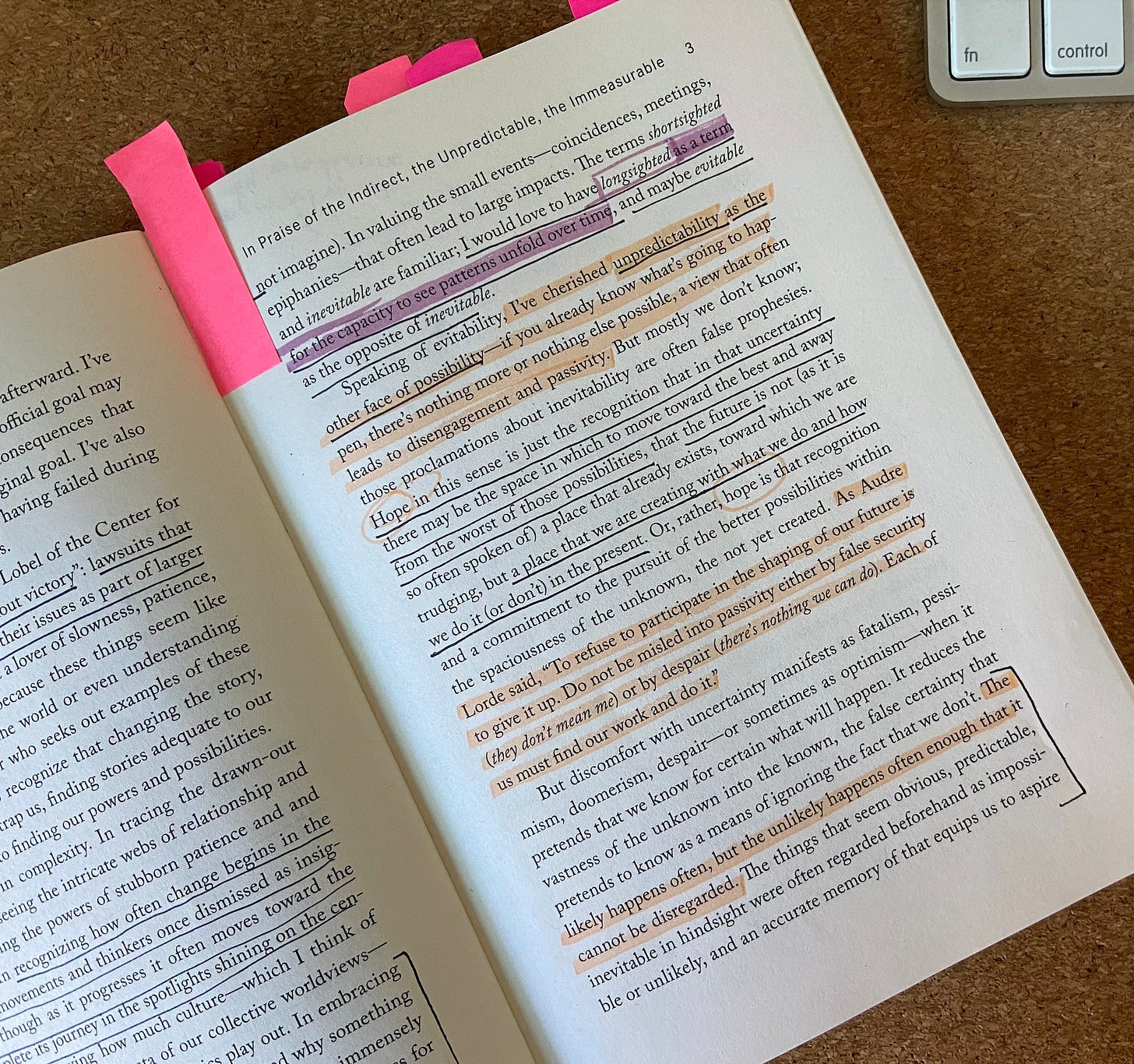 a photo of page 4 in Rebecca Solnit’s book, No Straight Road Takes you There. Multiple passages are underlined and highlighted, and neon pink post-it note tabs stick up from the top of the book. 