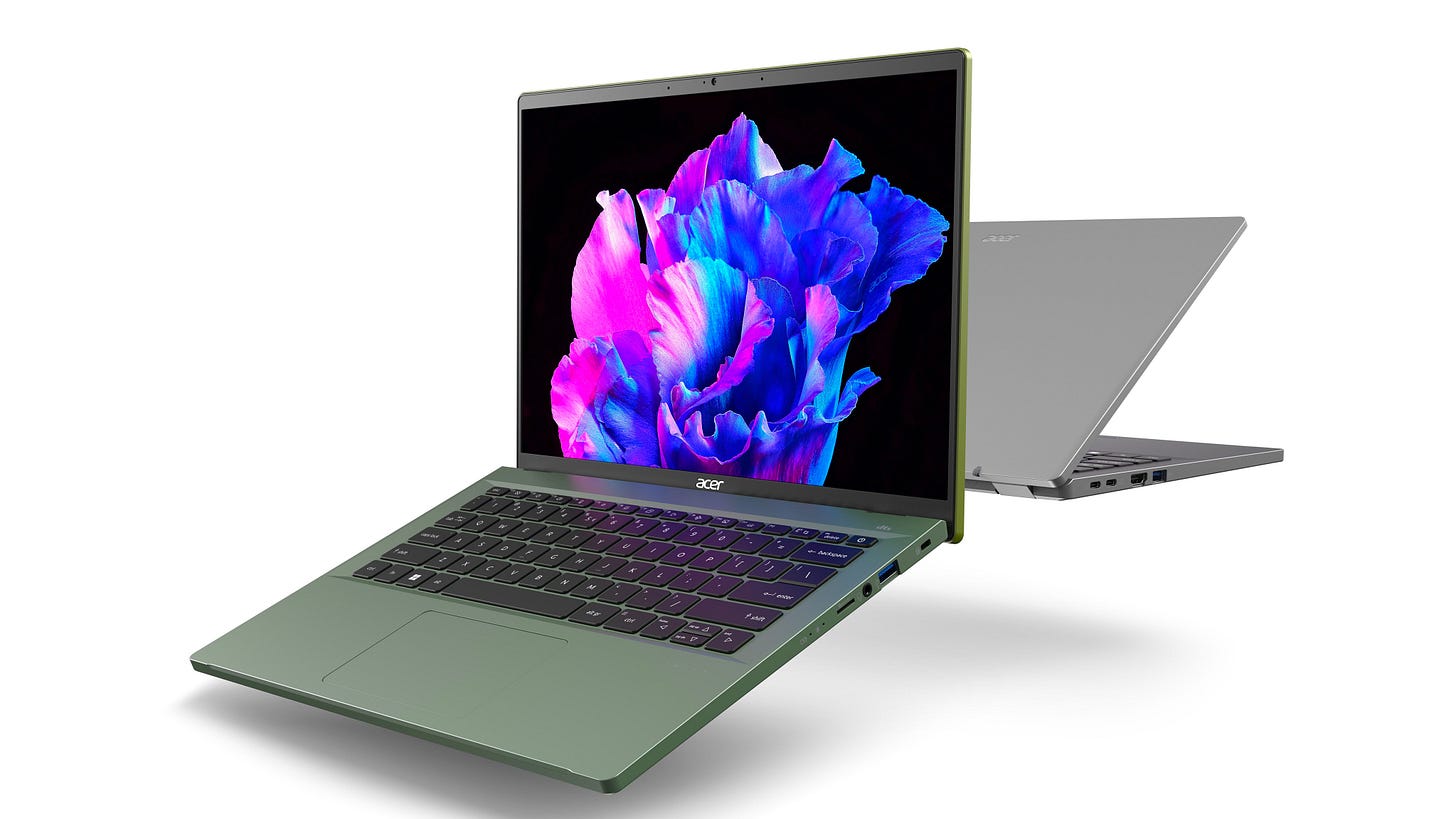 An Acer Swift Go 14 in green faces the camera while another one in silver, behind it, faces away An Acer Swift Go 14 in green faces the camera while another one in silver, behind it, faces away