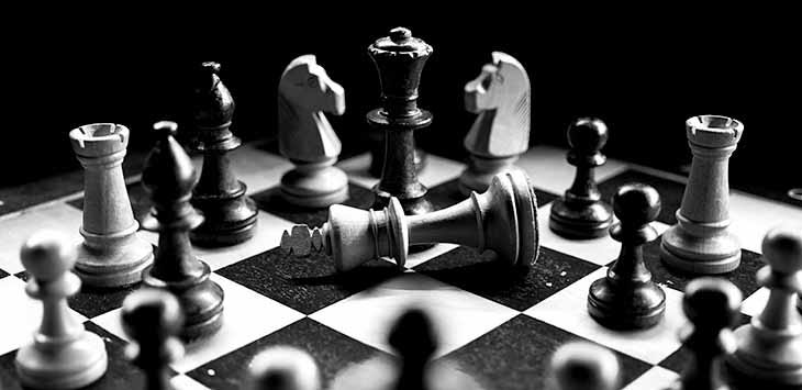 Photo of a chess set with the black king knocked down in check-mate.