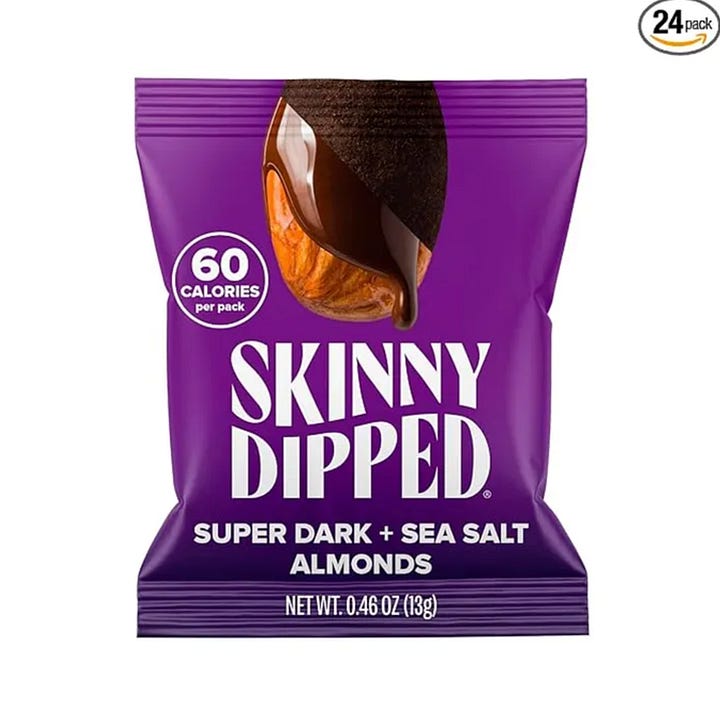 A box of Mezcla protein bars, LMNT electrolyte packets, a bag of Skinny Dipped chocolate almonds, Nespresso pods.