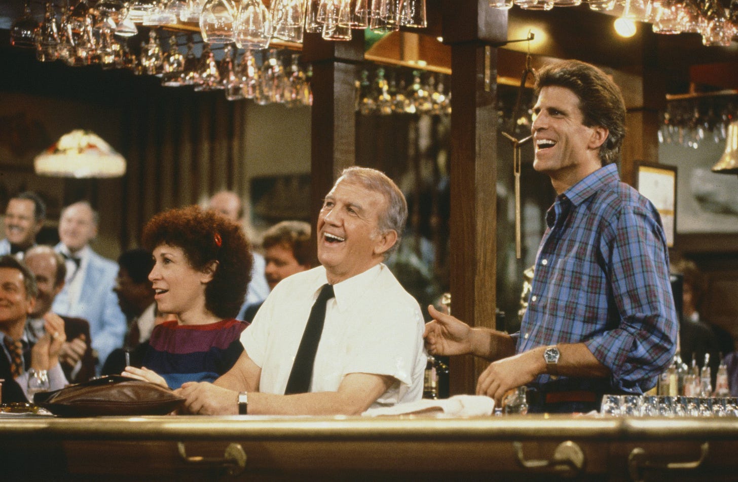 Carla, Coach, and Sam all behind bar laughing in Cheers Carla, Coach, and Sam all behind bar laughing in Cheers