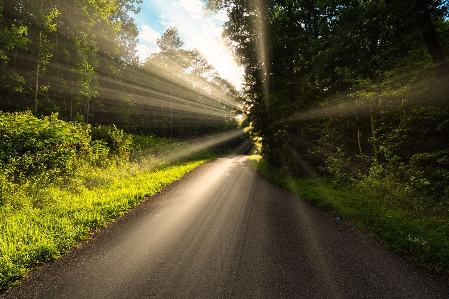 Concept of someone walking a tough road in life, but the light, happiness and salvation  is just ahead on the next curve.