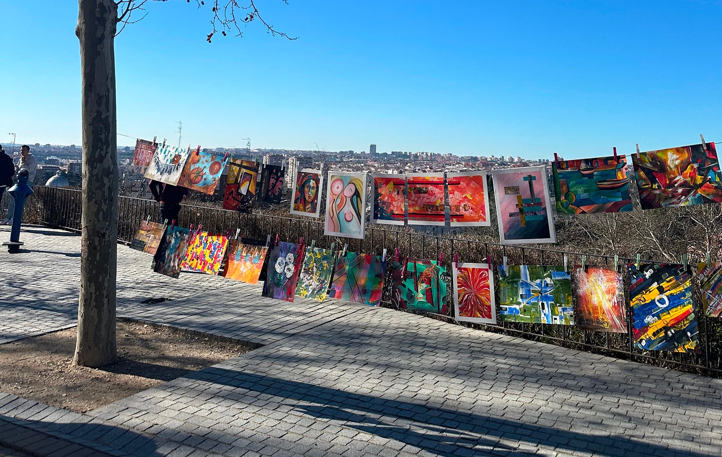 paintings pegged on a rope hung between two trees paintings pegged on a rope hung between two trees