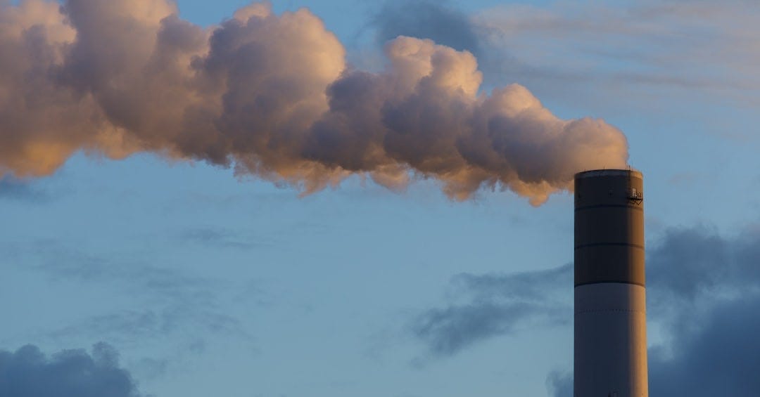 a smokestack emits from the top of a building