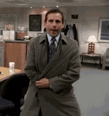 Michael Scott from The Office opens his trenchcoat to reveal a finger poking out from his fly 