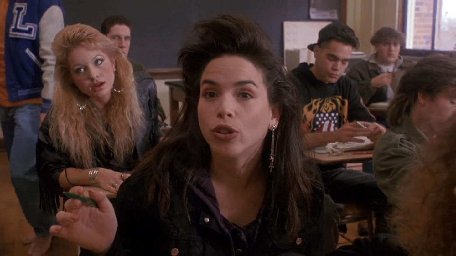 Kate Slavin (Tasia Valenza) in de schoolbanken, omringd door haar klasgenoten in Sometimes They Come Back (1991).