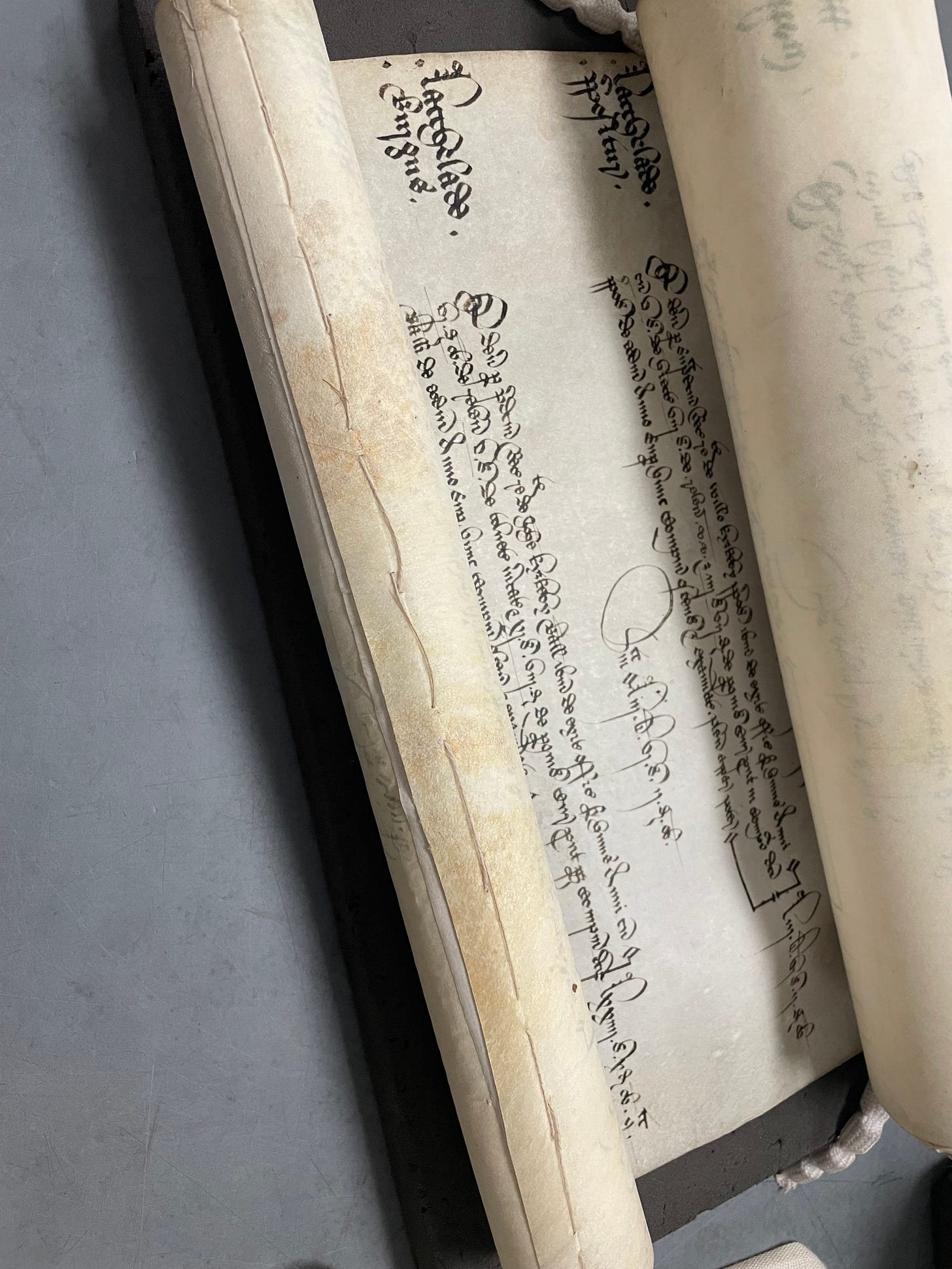 Parchment rolls, held together by large stitches.
