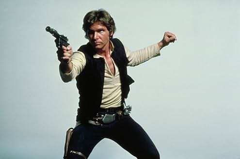 Harrison Ford as Han Solo pointing a gun (neutral background) in Star Wars: Episode IV - A New Hope PhotoL IMDB-Lucas Films 