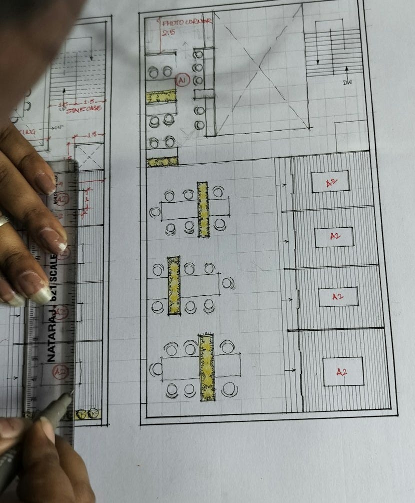 a person is drawing a floor plan on a piece of paper