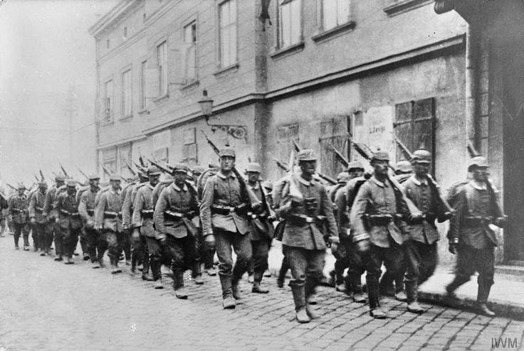 This may contain: an old black and white photo of soldiers marching down the street
