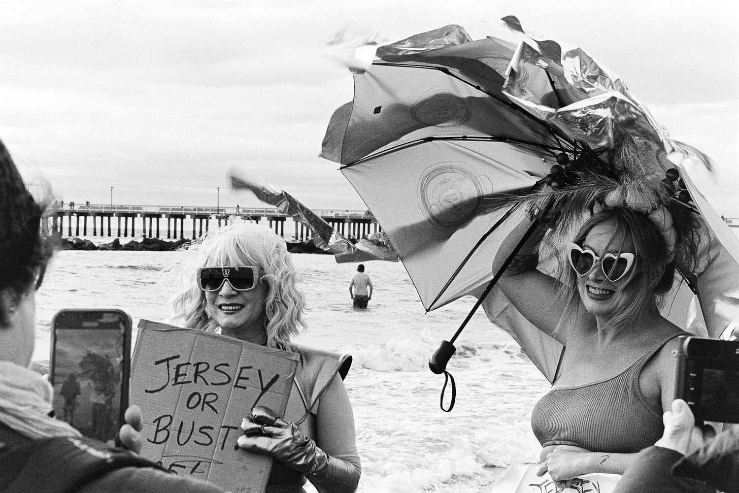 Two women holding jersey or bust signs. 