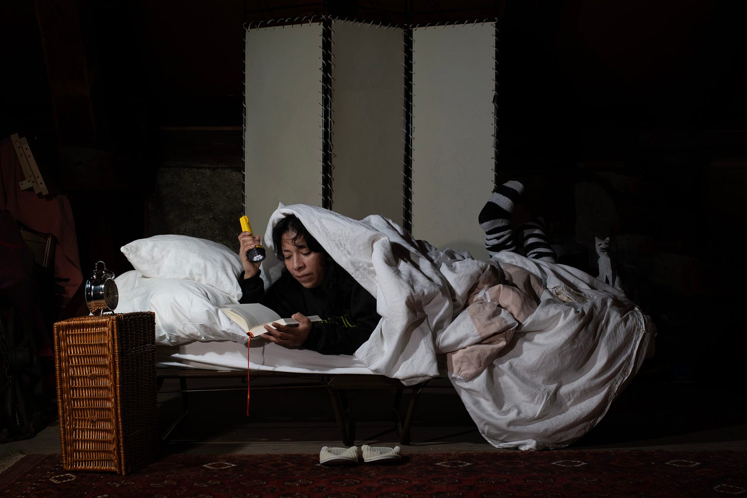 “Das Buch/The Book” by Pascale Florio: Woman reading by flashlight