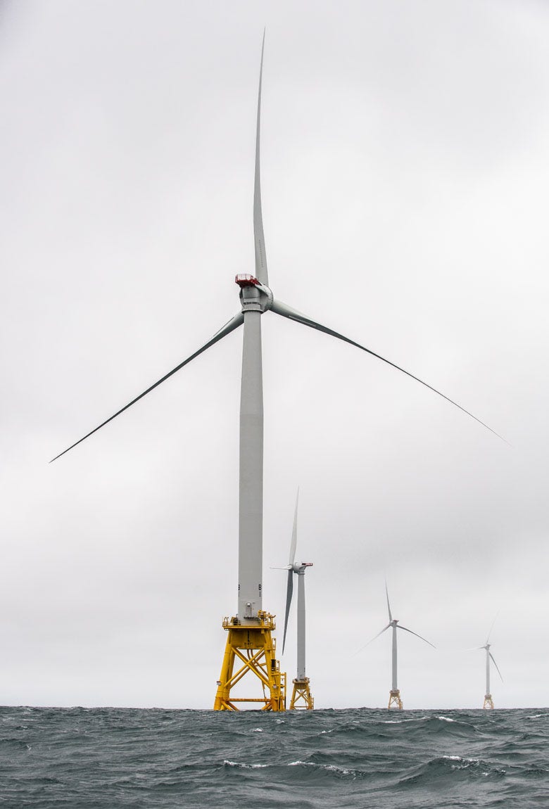 A group of offshore wind turbines rise over the ocean A group of offshore wind turbines rise over the ocean