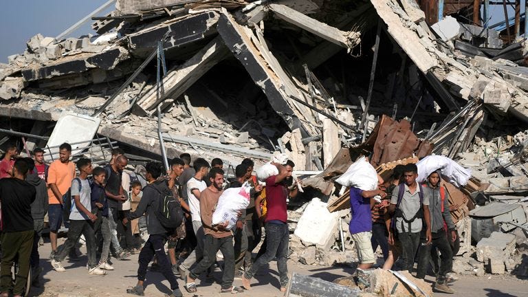 Palestinians carry humanitarian aid packages distributed by the Gaza Humanitarian Foundation in Khan Younis.
Pic: AP Palestinians carry humanitarian aid packages distributed by the Gaza Humanitarian Foundation in Khan Younis.
Pic: AP
