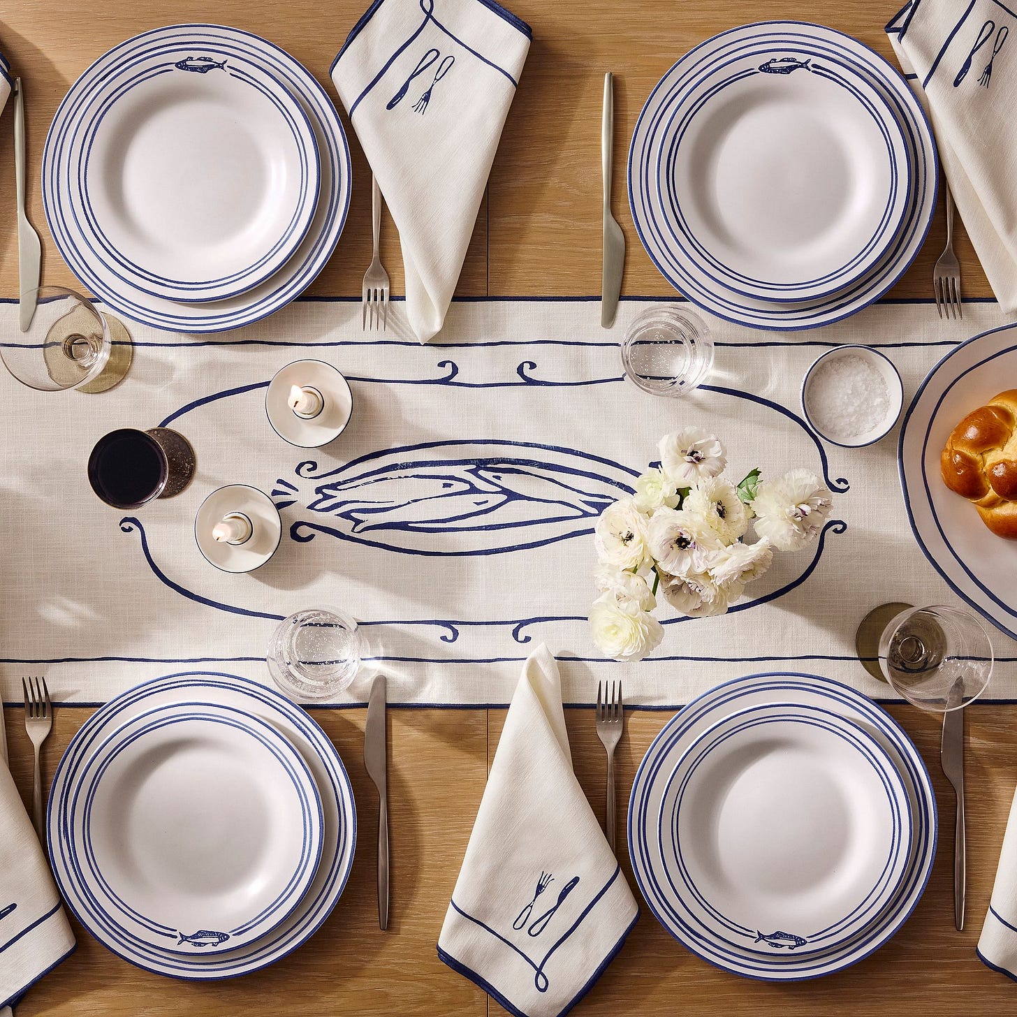Overhead view of dining table set with blue-and-white runner and matching stoneware dishes