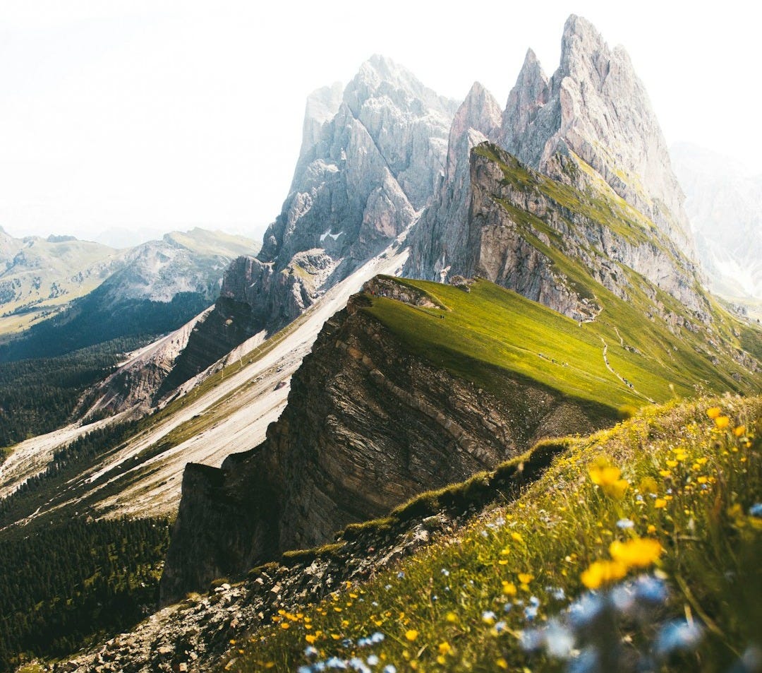 green grass and gray rocky mountain during daytime green grass and gray rocky mountain during daytime