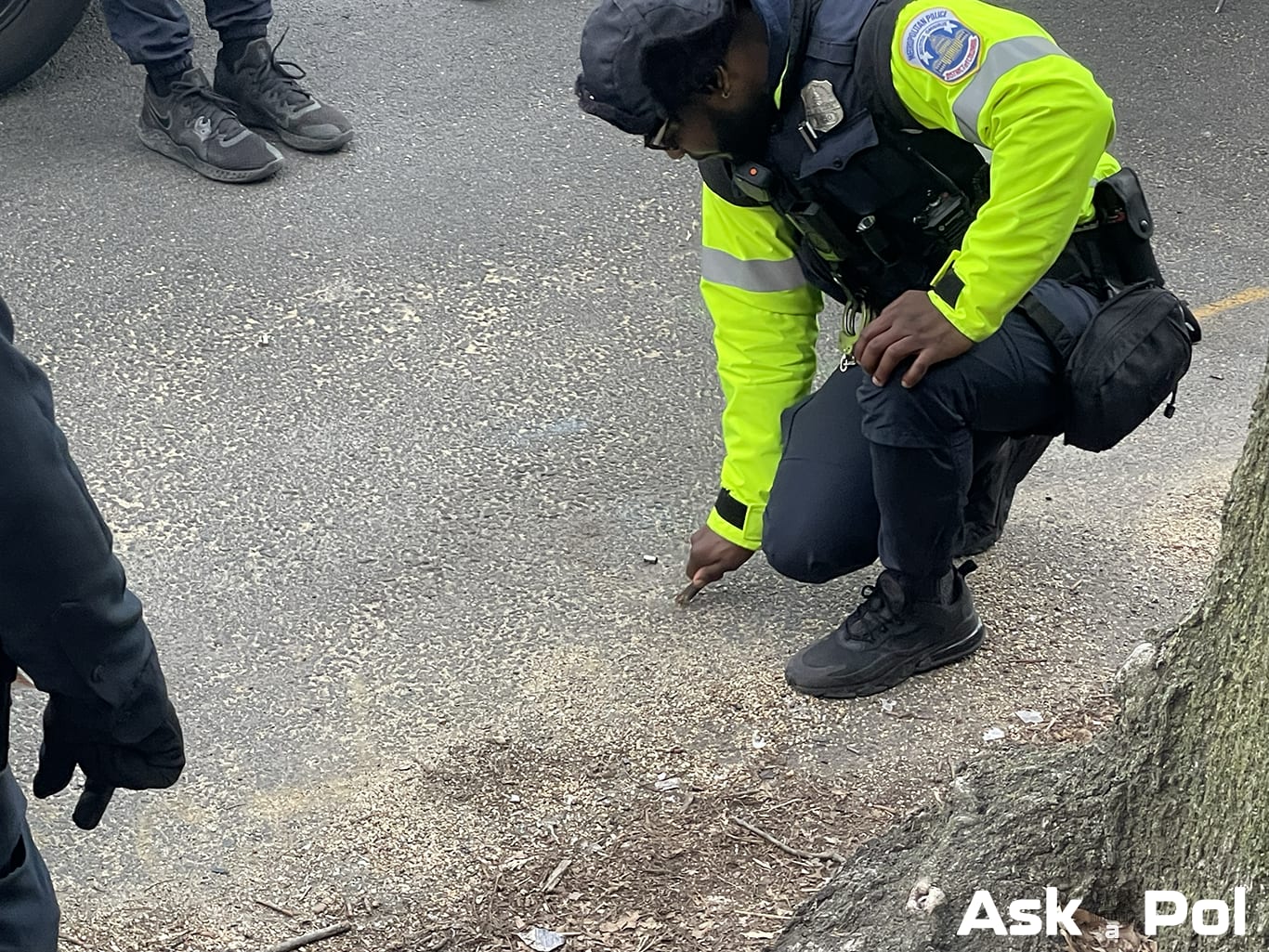 A police officer bends down to mark a shell casing after a shooting. Photo: Matt Laslo © www.askapol.com