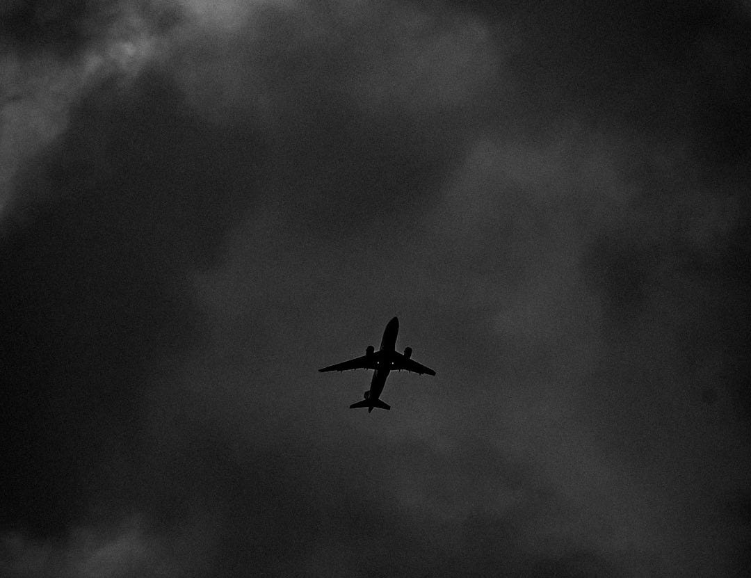 an airplane is flying through a cloudy sky an airplane is flying through a cloudy sky