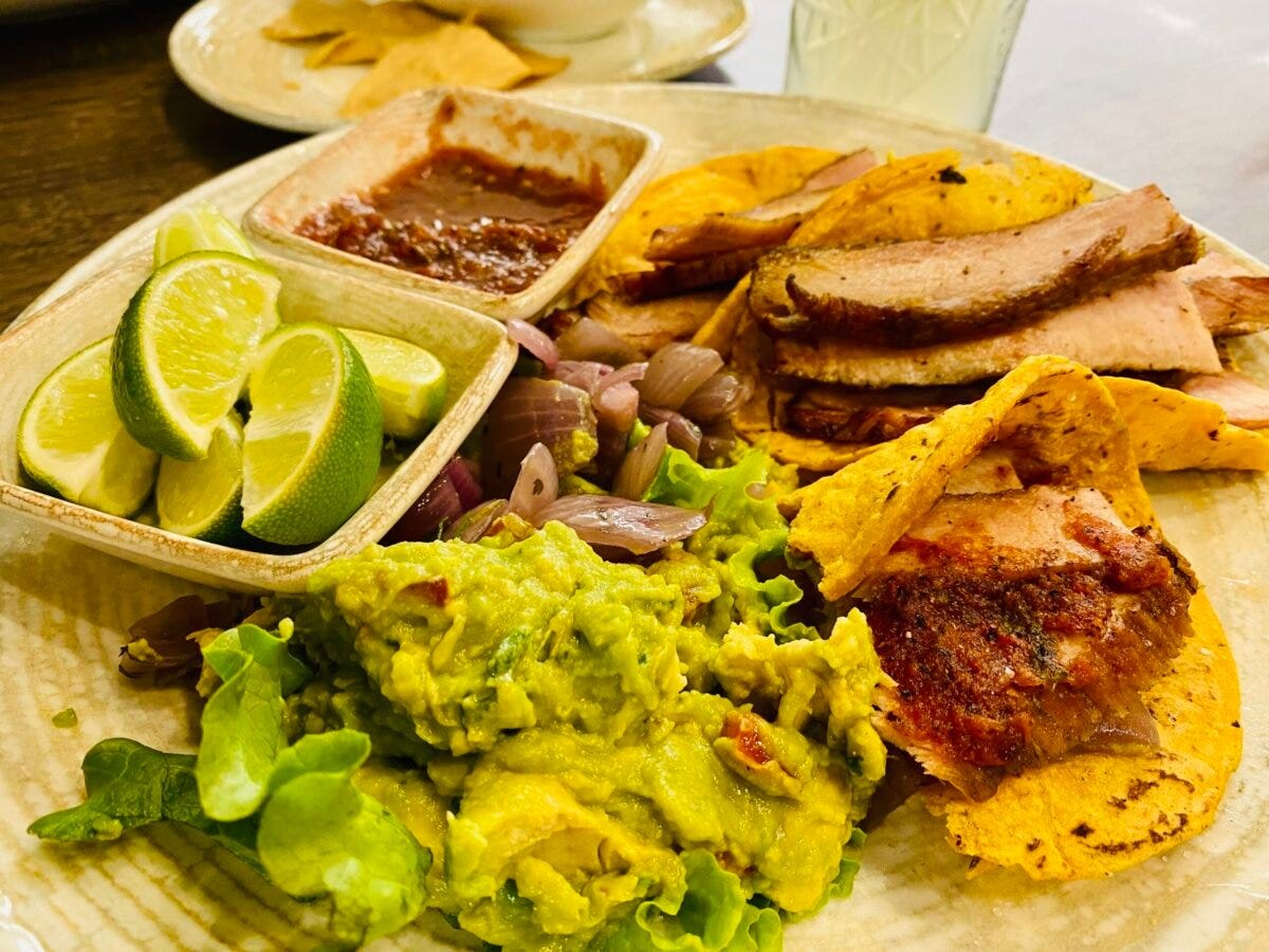 late of traditional Yucatecan tacos with guacamole, pickled red onion, salsa, and lime served at a restaurant in Mérida
