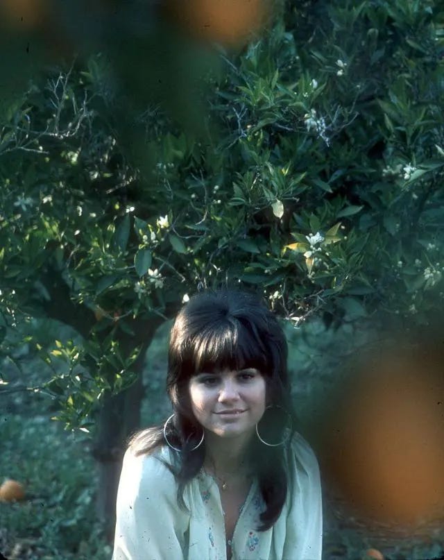 An iconic shot of young Linda Ronstadt, effortlessly captivating the audience. An iconic shot of young Linda Ronstadt, effortlessly captivating the audience.