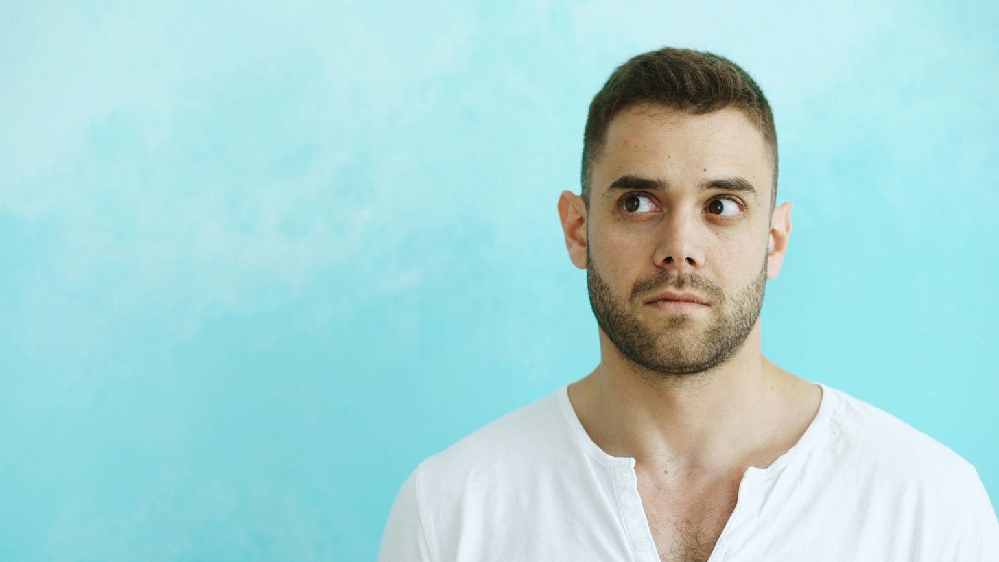 Man on soft blue background looking to the side