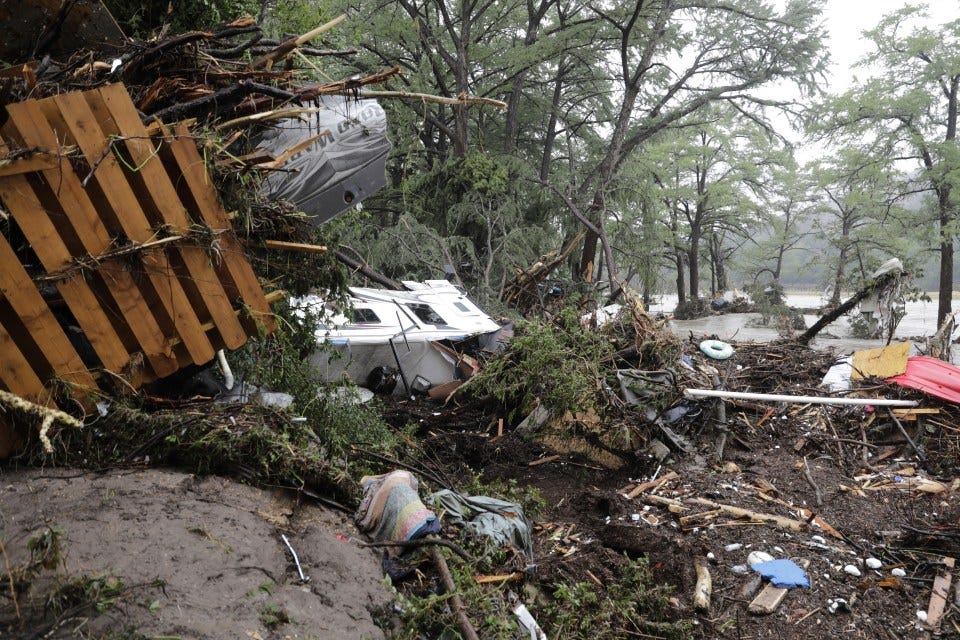 Flood debris and damaged vehicles in Ingram, Texas.