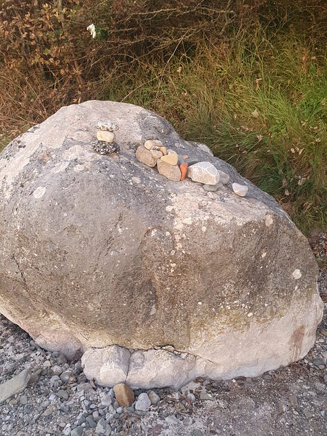 9 pictures of one large rock, each picture has different configurations of small rocks piled on top of it
