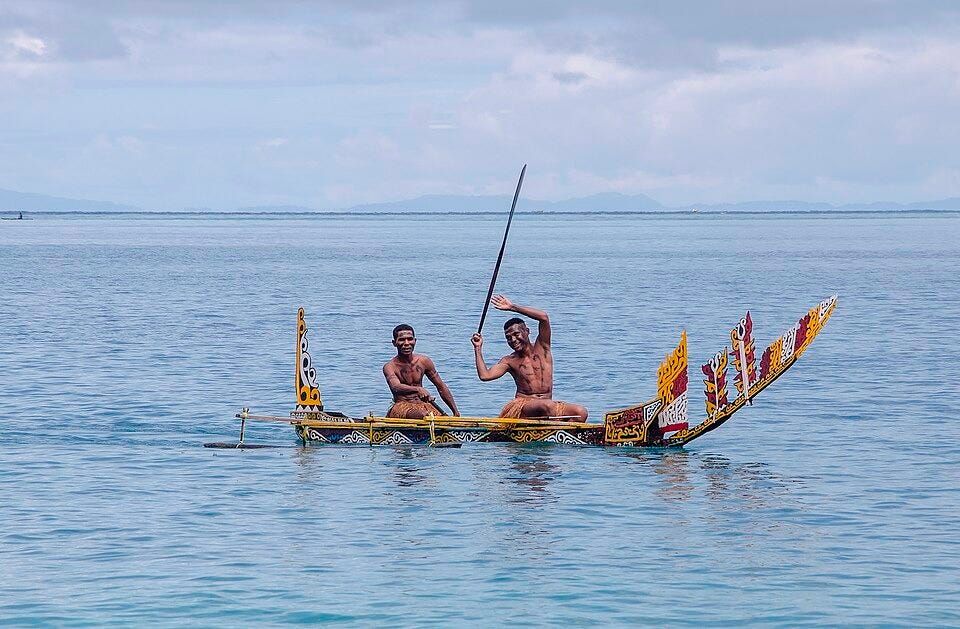 Two Biak residents are in the middle of a decorated boat in the middle of the ocean during an annual decorated boat competition in Biak.