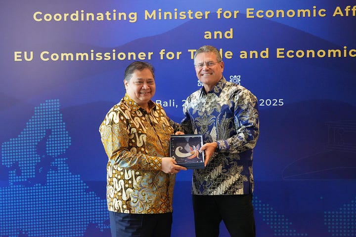 Indonesian Coordinating Minister for Economic Affairs Airlangga Hartarto shakes hands with EU Trade Commissioner Maroš Šefčovič during a bilateral meeting in Bali, September 23, 2025. Officials from both delegations are seated nearby, with flags of Indonesia and the European Union in the background.