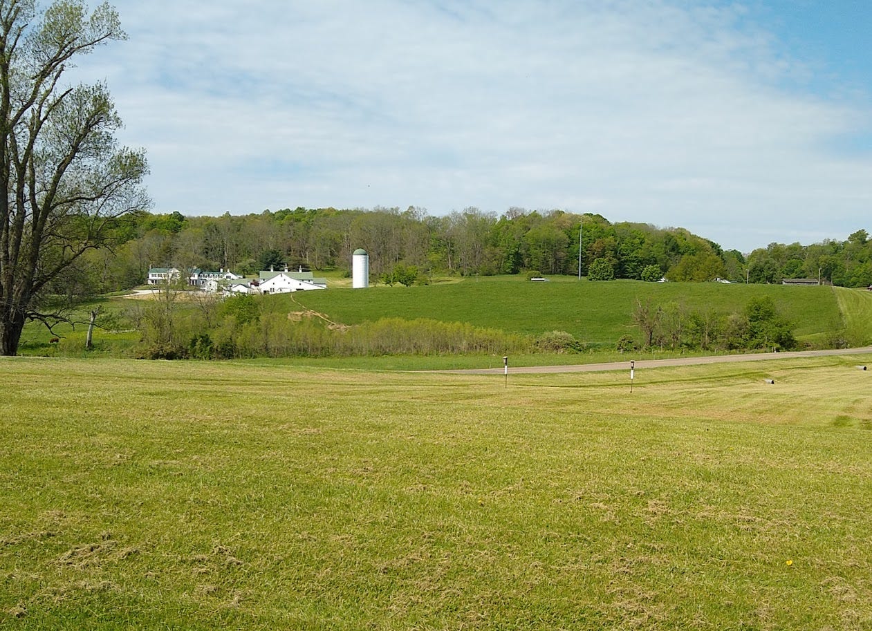 Farm buildings and large fields of grass Farm buildings and large fields of grass