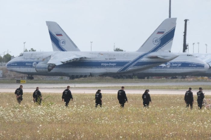 Police officers search a field at Leipzig Airport for a drone.