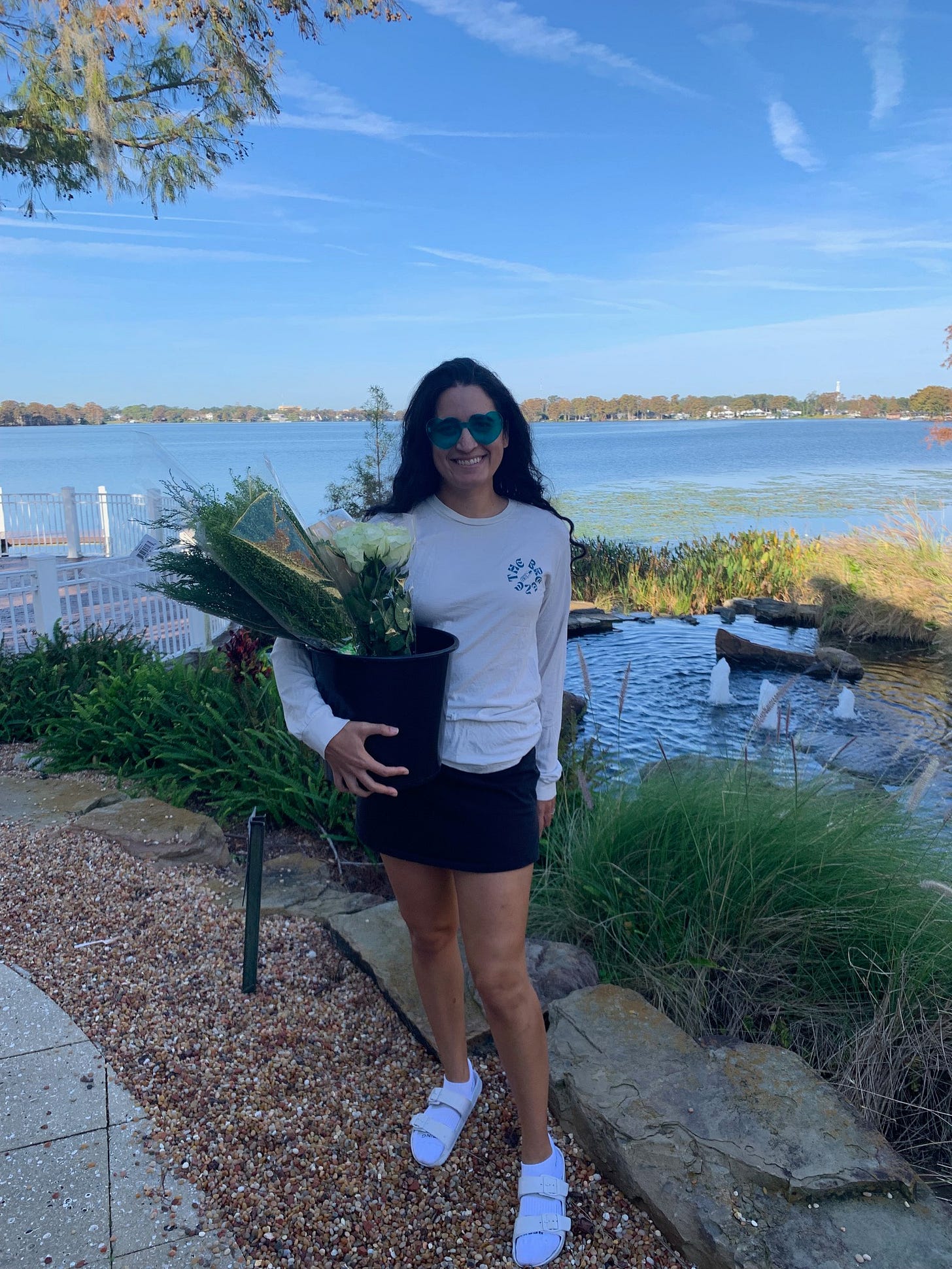 Kayla holds a buvket of florals next to a lake in Orlando
