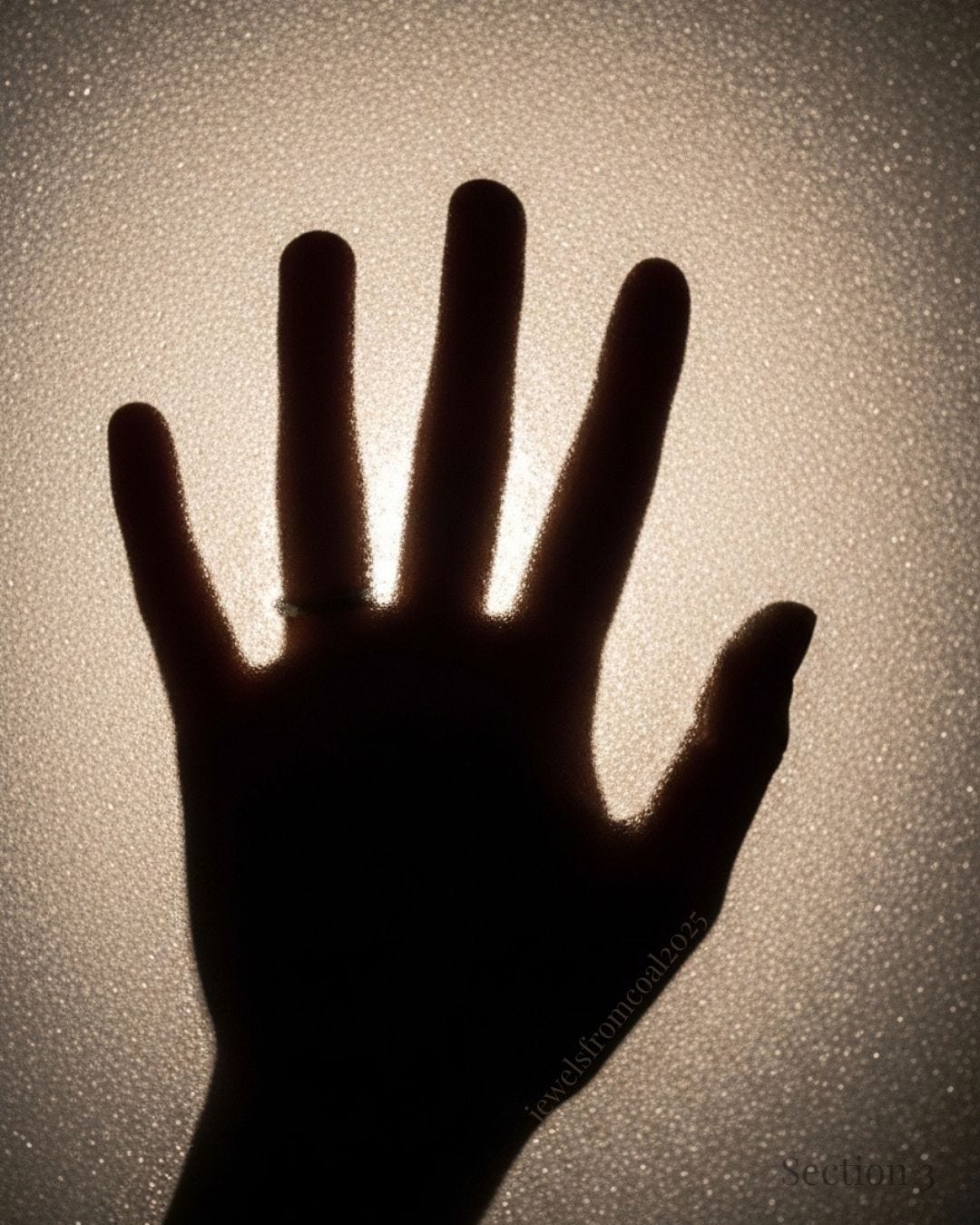 A silhouetted hand presses against frosted glass, backlit by warm light. The texture of the glass diffuses the glow, creating a sense of reaching out through distance, fear, or separation.