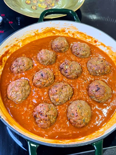 Photo 1: Overhead side shot of jerk chicken meatballs in a rich tomato sauce Photo 2: Tomato sauce cooking in a pan with teaspoonfuls of seasoning powder Photo 3: Two bowls of linguine pasta with the meatballs and tomato sauce with a small coating of grated parmesan cheese