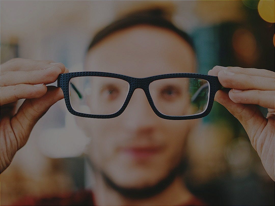person holding eyeglasses with black frames