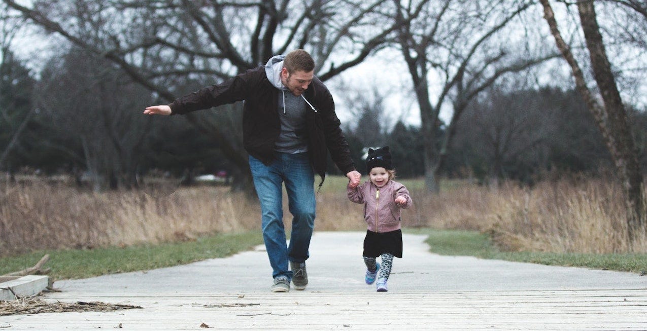 Father walking with his toddler, hand in hand Father walking with his toddler, hand in hand