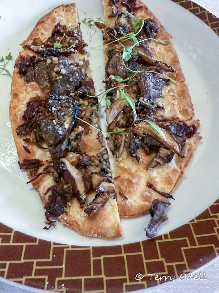 two slices of mushroom flatbread on a white plate