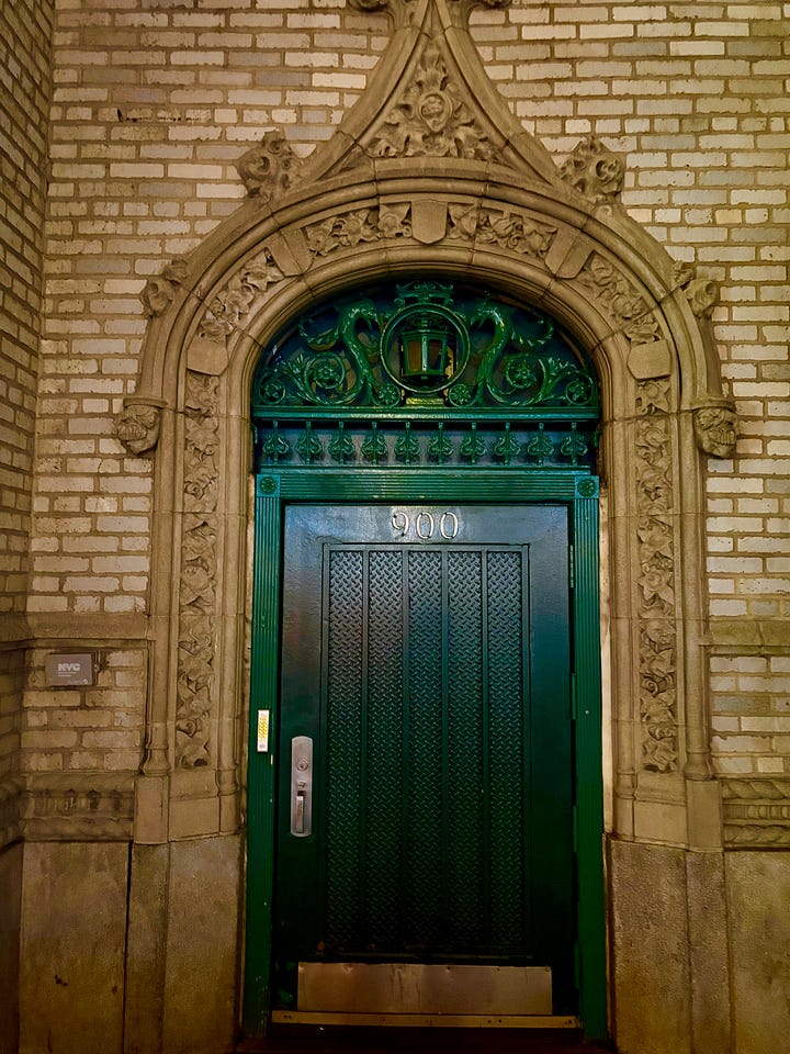 Bronze statue of a butt, New York skyscrapers lit up at night, Jenny in an elevator making a funny face at the mirrored ceiling, a green door.