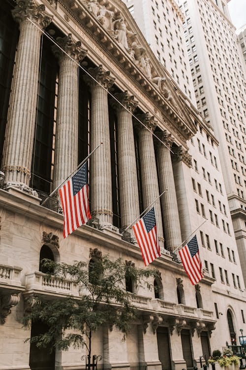 Free Iconic New York Stock Exchange with American flags on Wall Street, USA. Stock Photo