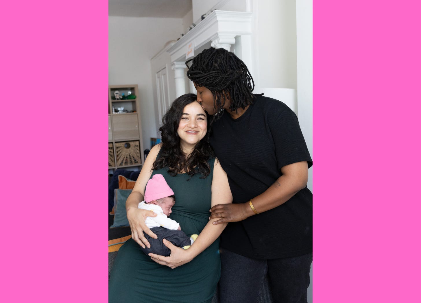 Two women standing together. One is holding a baby.
