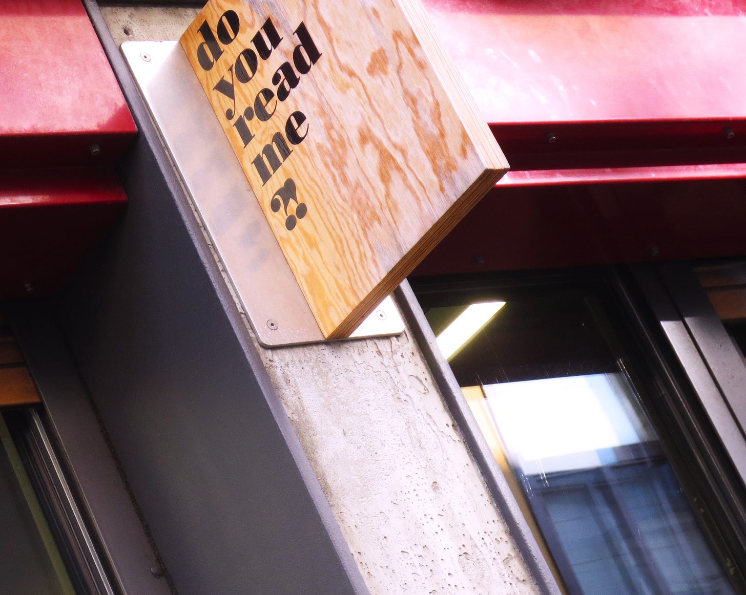 Fotografia dell'insegna (con testo nero dipinto su legno naturale) di un negozio che dice "do you read me?!". Fotografia dell'insegna (con testo nero dipinto su legno naturale) di un negozio che dice "do you read me?!".