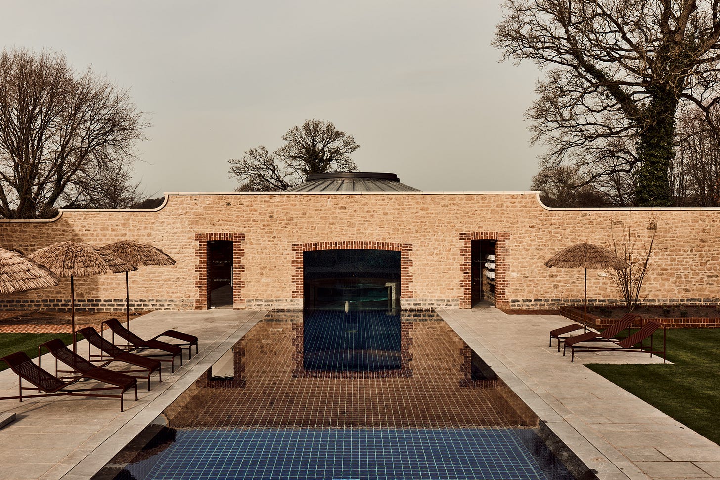 view of a bucolic british country house with a serene swimming pool