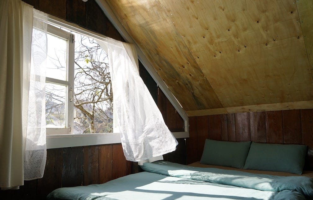 Cozy attic bedroom with a bed and window Cozy attic bedroom with a bed and window