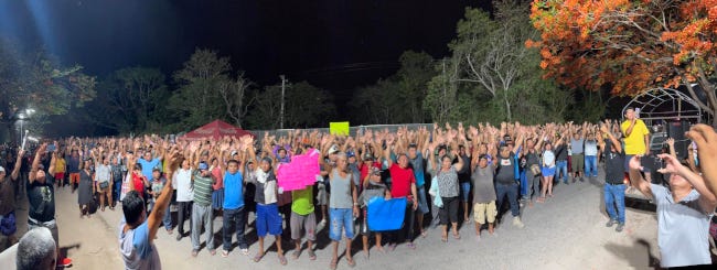 Une foule rassemblée, la nuit, portant panneaux de revendication, prête à bloquer. Une foule rassemblée, la nuit, portant panneaux de revendication, prête à bloquer.