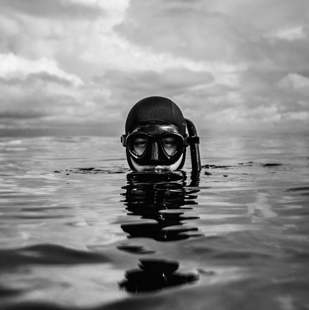 grayscale photo of person wearing goggles on water